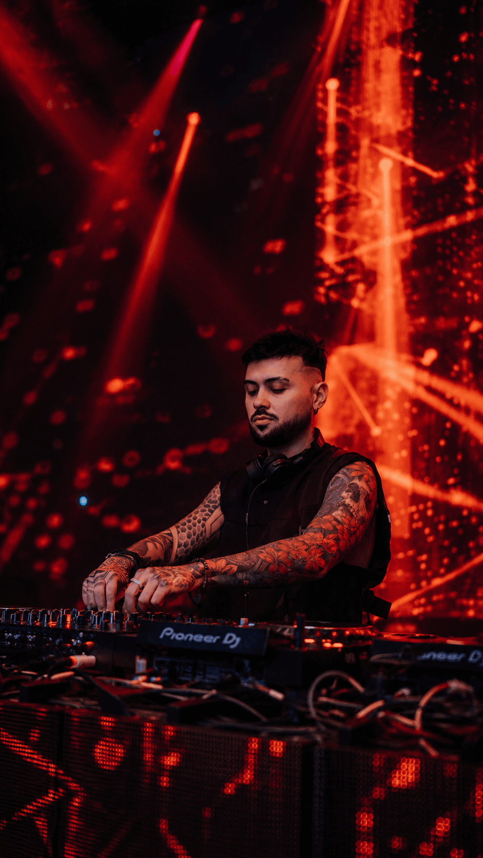 Christopher Erre at the decks against vivid red stage lighting